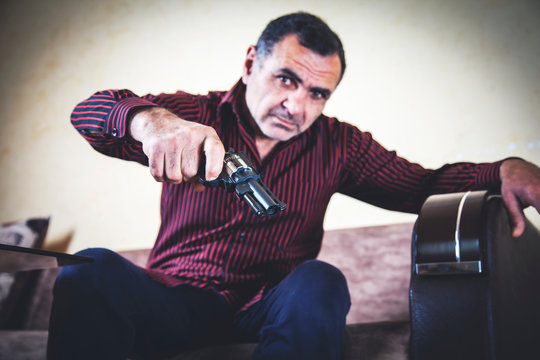man hand gun sitting on sofa