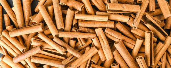 Cinnamon stick background wide baner or panorama top view.