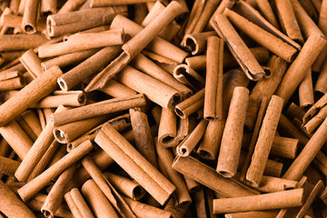 Cinnamon background. Pile of cinnamons stick top view.