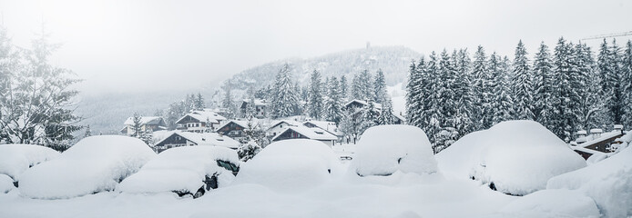 Many cars covered with heavy fresh snow after storm or blizzard in winter country.