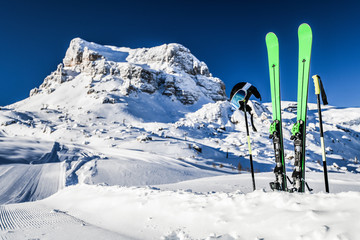 Skis in snow, mountains and ski concept equipments in sunny winter day. Fresh or new groomed slope...