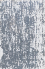 Close-up of a gray wall with white paint badly scratched and peeled off. High resolution full frame abstract background. Copy space.