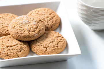 Sweet cookies in square white plate on white table for tea time