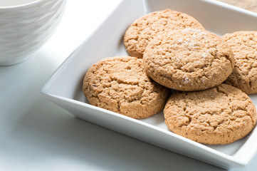 Sweet cookies in square white plate on white table for tea time