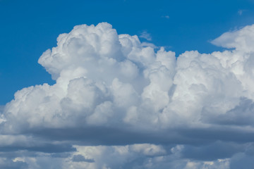 Naklejka na ściany i meble closeup huge cumulus cloud on a blue sky, beautiful outdoor background