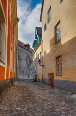 Fototapeta na wymiar Tallinn city, Estonia, narrow, cobbled stone streets of the town, behind the main wall of a medieval castle