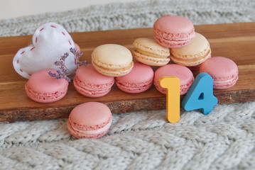 Pastel macarons with heart and lavender on a rustic background with number 14. Concept postcard for Valentine's Day.