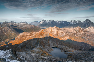 Panorama view from the mountain Rundfjellet to the surrounding snow capped peaks and the sea on the Lofoten Islands, Norway