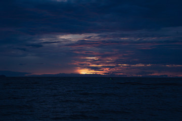 The sunset to the horizon at sea. Causing the sky to alternate orange and blue.