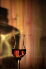 A glass of whiskey against the shadow of the bottle