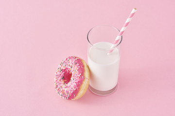 Donuts with glass of milk on a pink background