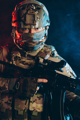 brave and strong soldier in military uniform holding rifle in hands. military service concept