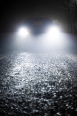 blurred car lights in foggy night. car traveling at night with focus on road.