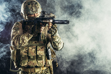 military, army, soldiers concept. brave young soldier prepare to attack holding gun in white foggy...