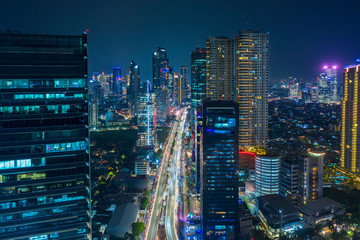Aerial view of glowing buildings in hectic traffic