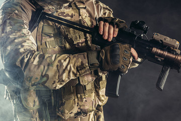 Fototapeta premium defense and military forces concept. unrecognizable cropped soldier holding weapon in hands