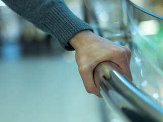 Man holding a hand rail in mall closeup. Stock photo