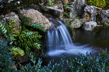 Small waterfall between rocks and plants
