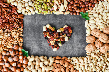 Mixed nuts in bowl on black stone table. Almonds, pistachio, walnuts, cashew, hazelnut. Top view nut healthy food.