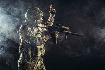 young military man soldier holding gun, wearing special services uniform, stand in smoky space. defend concept