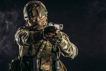 young military, soldier man holding gun wearing military wear, green camouflage and helmet on head,...