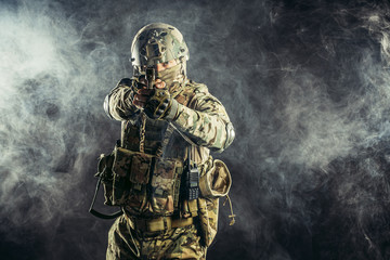 brave and strong soldier in military uniform holding rifle in hands. military service concept