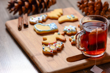 Gingerbread and christmas cookies and festive decor with hot tea on wooden background with a place for text