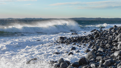 Brihgt day  by the spectacular stony sea coast in storm weather in  South Norway