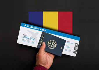  Hand holds passport and boarding pass with flag of Chad