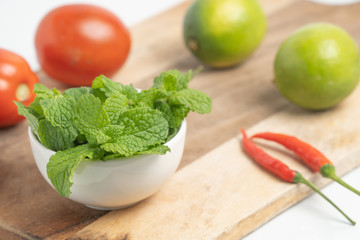 peppermint in small cup on board and  Vegetable with white background