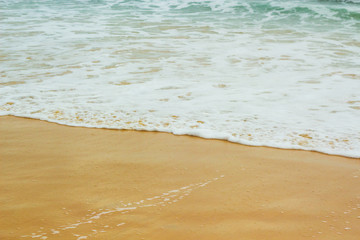 white sea foam on yellow sand, sea background, sandy beach