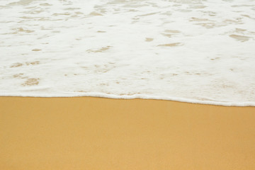 white sea foam on yellow sand, sea background, sandy beach