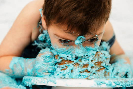 sesi&oacute;n smashcake, primer pastel de un ni&ntilde;o de 3 a&ntilde;os con pluri discapacidad. disfrutando muchismo mientras come y se ensucia de nata azul