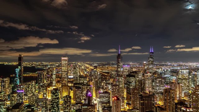 An incredible aerial night time lapse of downtown Chicago highrise buildings with lights looking south on Michigan Avenue, the magnificent mile as traffic moves below.