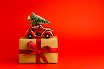 Brown gift boxes with red ribbons and red toy car on red trendy background. Banner for Christmas or New Year