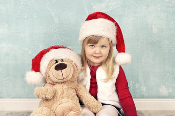 kleines Mädchen mit Teddy - Weihnachtsgeschenk