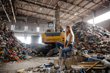 Nature pollution activist at a huge trash dump - Young blonde woman - Looking at all the human...