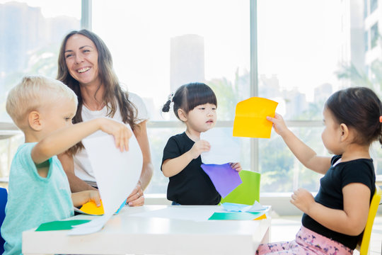 Teacher laughing while her pupils creating frenzy - Powered by Adobe