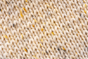 Texture of Wool Knit Beige Fabric Interspersed with Yellow Yarn. Sweater Background Close-Up View