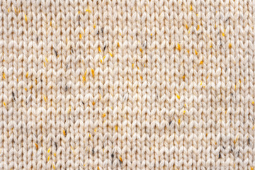 Texture of Wool Knit Beige Fabric Interspersed with Yellow Yarn. Sweater Background Close-Up View