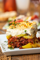 portion of greek moussaka on wood