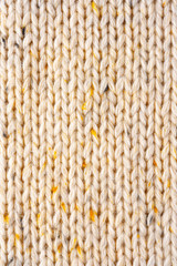 Texture of Wool Knit Beige Fabric Interspersed with Yellow Yarn. Sweater Background Close-Up View