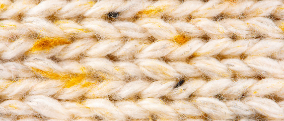 Texture of Wool Knit Beige Fabric Interspersed with Yellow Yarn. Sweater Background Close-Up View
