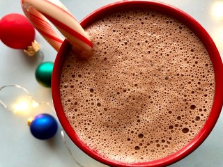 Overhead view of a mug of hot cocoa with candy cane