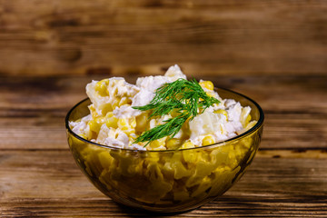 Festive salad with chicken breast, canned pineapple, cheese, sweet corn and mayonnaise on wooden table