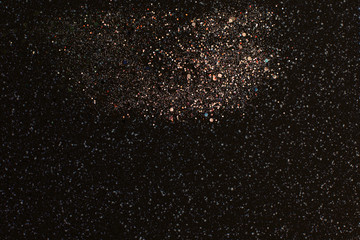 Christmas Gold glitter on black background. Holiday abstract texture