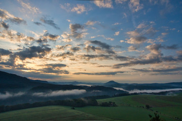 Fototapeta premium Faszinierende, beeindruckende Morgenstimmung mit Nebel über den Elbe, Täler im Nationalpark Sächsische Schweiz. Blick von der Kaiserkrone auf Zirkelstein, Rosenberg, Schrammsteine bis Lilienstein.