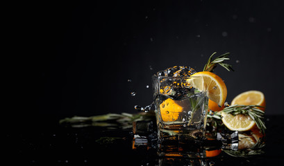 Cocktail gin-tonic with lemon slices and twigs of rosemary. - obrazy, fototapety, plakaty