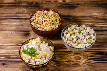 Set of festive mayonnaise salads on wooden table
