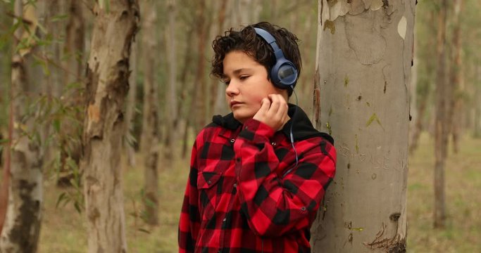 Teenage boy has allergies with mosquitoes bite. Listening to music in the forest